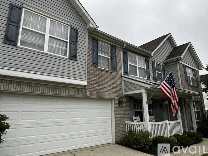 A house with a garage and an American flag on the porch.