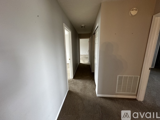 A long hallway with a carpeted floor and white walls.