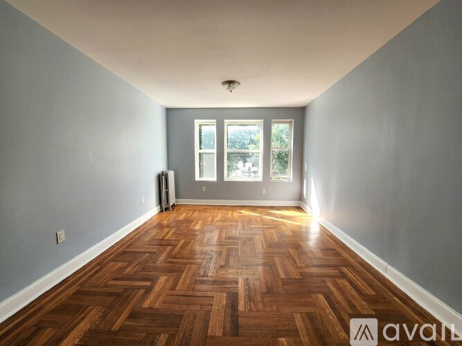 A room with wooden flooring and a window.