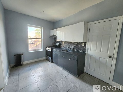 A kitchen with a white door and cabinets.