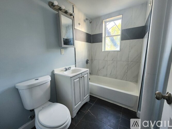 A white toilet sits next to a sink in a bathroom.