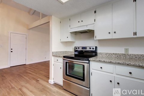 A kitchen with white cabinets and a stainless steel oven.