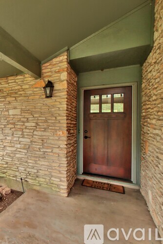 A brown door is on a stone wall.