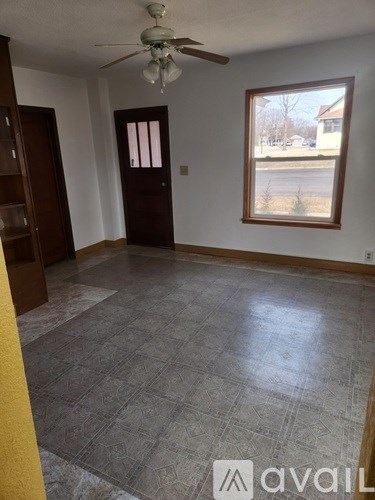 A room with a ceiling fan and a door.