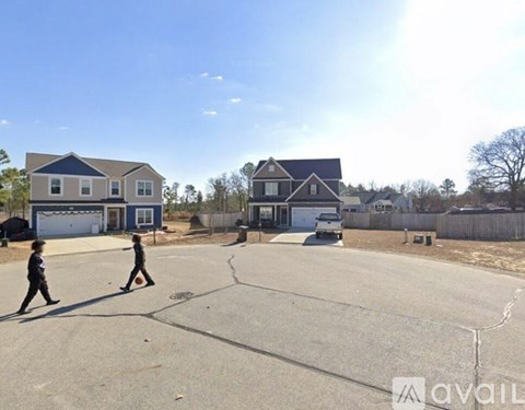 Two children playing basketball on a sunny day in a residential area.