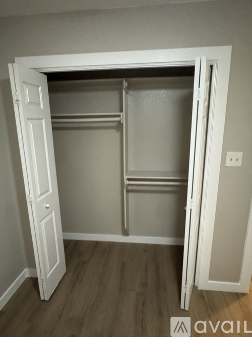 A white closet with shelves and a door open.