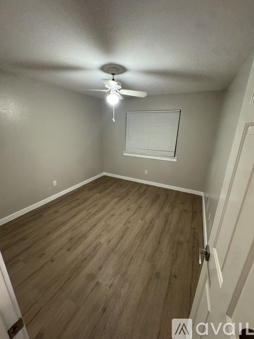 A room with wooden flooring and a ceiling fan.