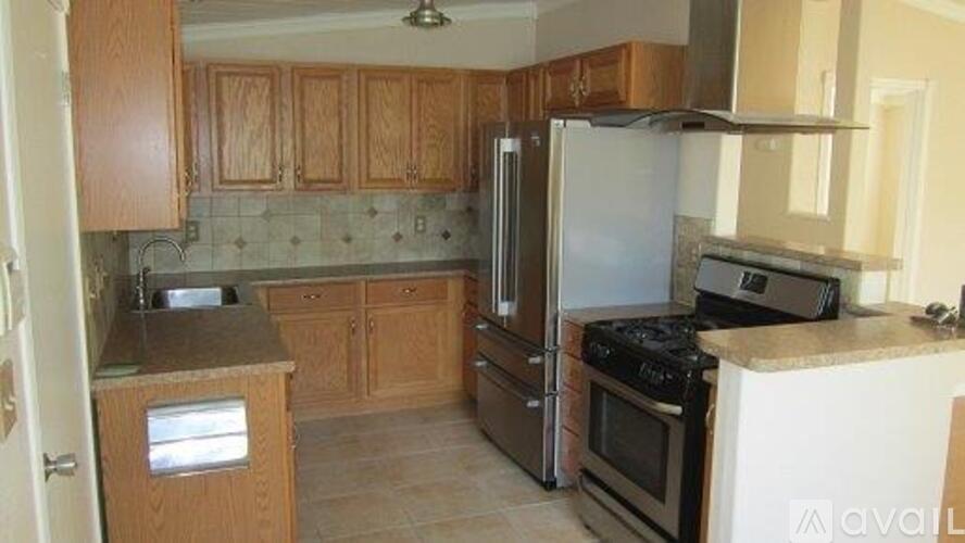 A kitchen with wooden cabinets and a tile backsplash.