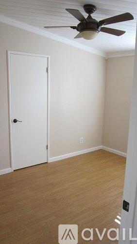 A room with a ceiling fan and a door.