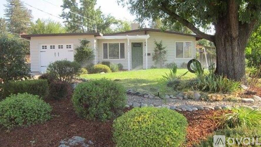 A house with a white exterior and a green lawn.