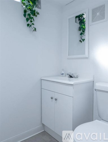 A white bathroom with a cabinet and a toilet.