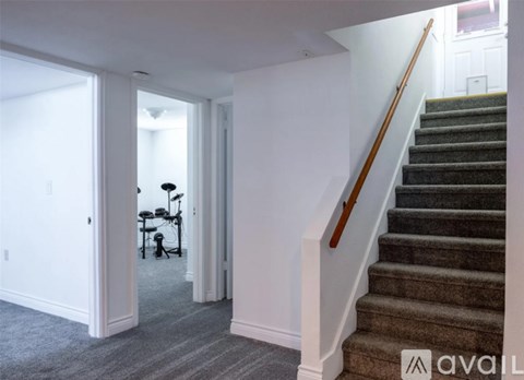 A staircase with a wooden handrail leads up to a second floor.