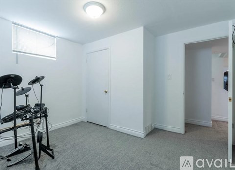 A room with a drum set and a window.