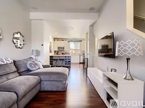 A living room with a grey couch and a white console table.