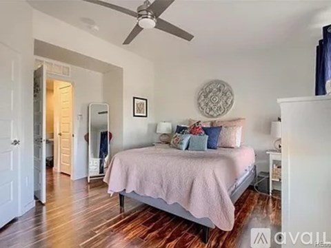 A bedroom with a bed, dresser, and a ceiling fan.