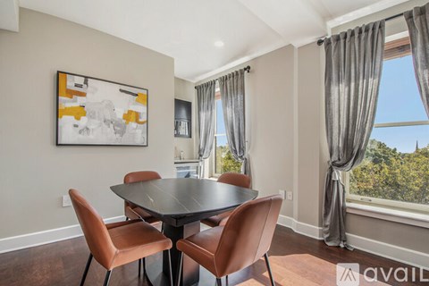 A dining room with a table and chairs.