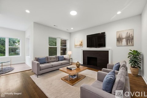 A living room with a grey couch, a fireplace, and a television.