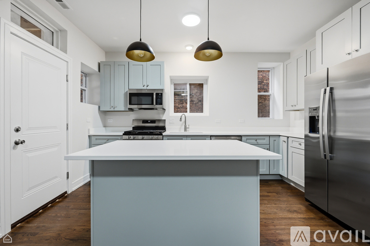 A kitchen with a white countertop and a stainless steel refrigerator.