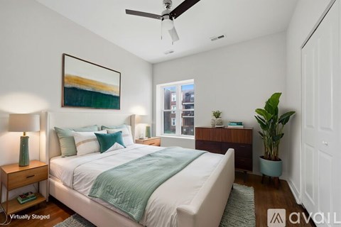 A bedroom with a bed, a ceiling fan, and a painting on the wall.