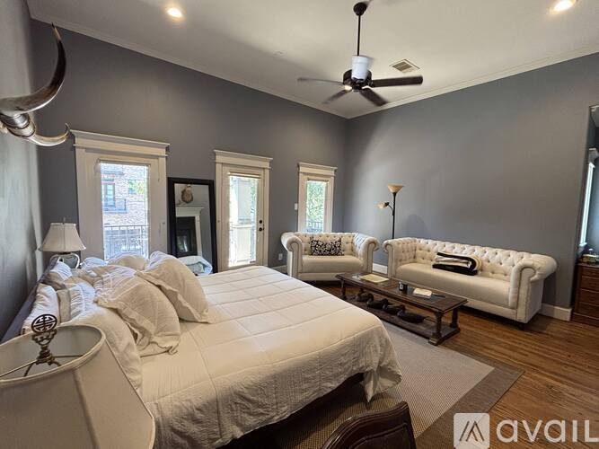 A bedroom with a large bed and a white couch.