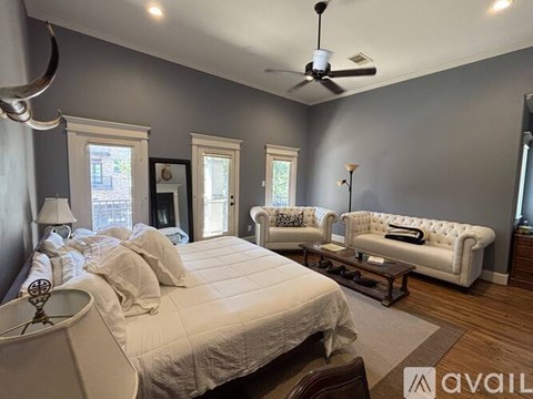A bedroom with a large bed and a white couch.