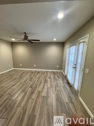 A room with wooden flooring and a ceiling fan.