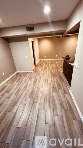 A room with wooden flooring and a ceiling fan.