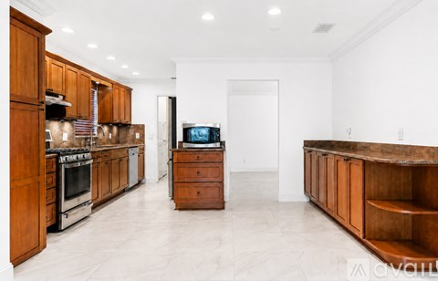 A kitchen with wooden cabinets and a white wall.