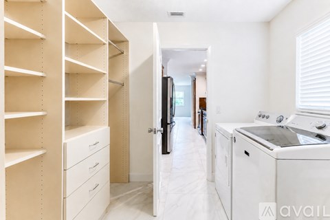 A kitchen with white appliances and cabinets.