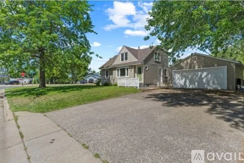 A house with a driveway and trees in front of it.