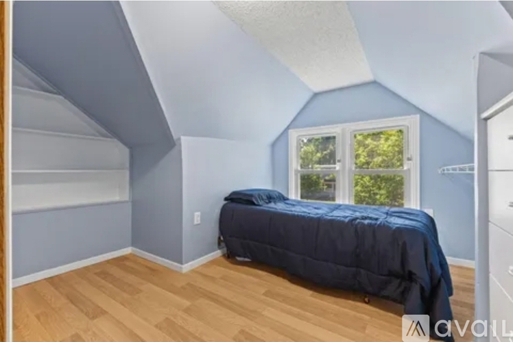 A bedroom with a bed and a window.