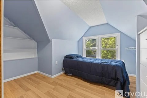 A bedroom with a bed and a window.