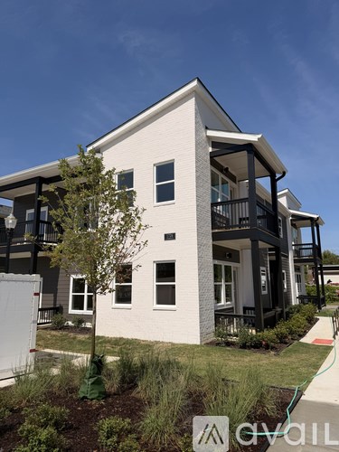 A modern two-story house with a white exterior and black accents.