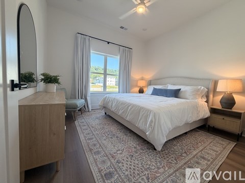 A bedroom with a large bed, a dresser, and a mirror.