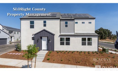 A modern house with solar panels on the roof is being managed by SLOright County Property Management.