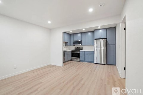 A kitchen with wooden floors and a white wall.