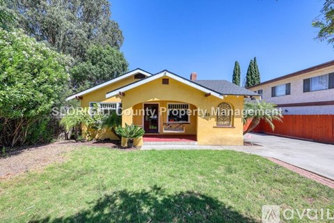 A yellow house with a sign that says "Sale" in front of it.