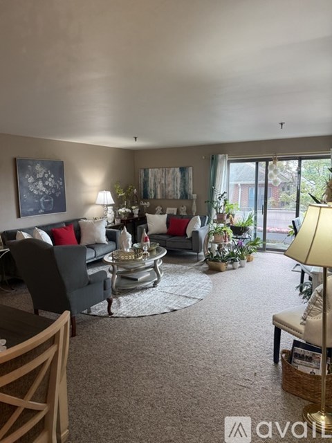 A room with a carpeted floor and a window with blinds.