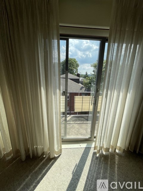 A room with a view of a house through a sliding glass door.