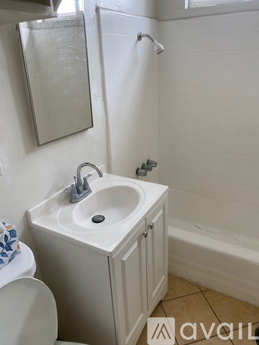 A white sink with a silver faucet is mounted on a white cabinet in a bathroom.