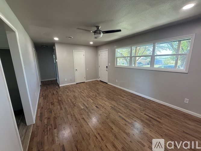A room with wood flooring and a ceiling fan.