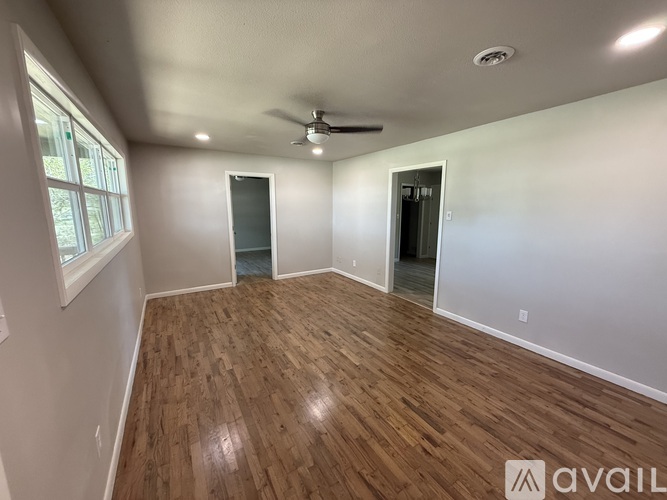 A room with wooden flooring and a ceiling fan.