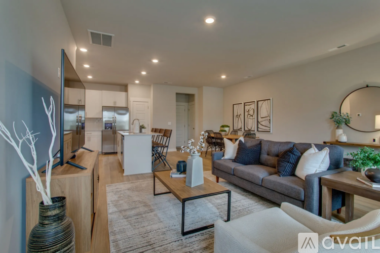A modern living room with a grey couch and a wooden coffee table.