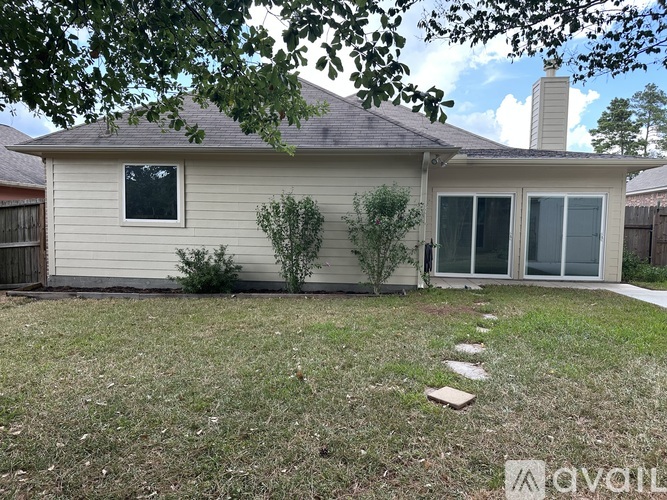 A house with a grey roof and a white wall with a window and a door.