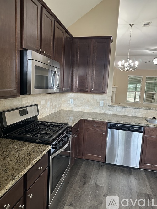 A kitchen with brown cabinets and a black stove top oven.