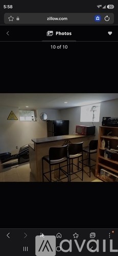 A photo of a room with a bar stool and a television.