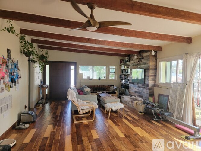 A living room with wooden floors and a ceiling fan.
