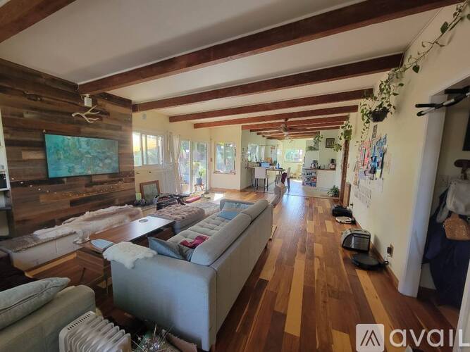 A living room with a couch, a TV, and a wooden wall.