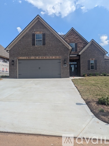 A brick house with a garage door and a driveway.