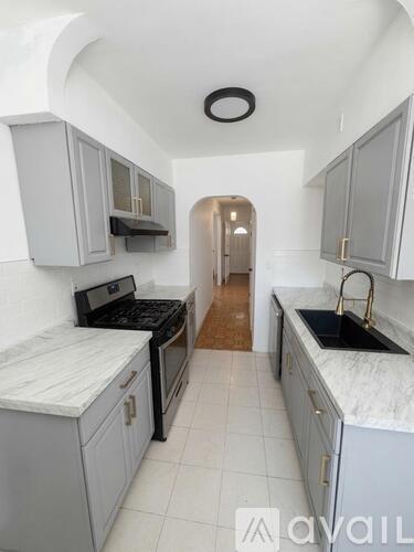 A kitchen with white cabinets and a black stove top oven.